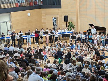 Die Aula des Dossenberger Gymnasiums ist bis auf den letzten Platz belegt bei der Knirpsmusik der Städtischen Musikschule Günzburg. Foto: Cornelia Bayr/ Musikschule Günzburg